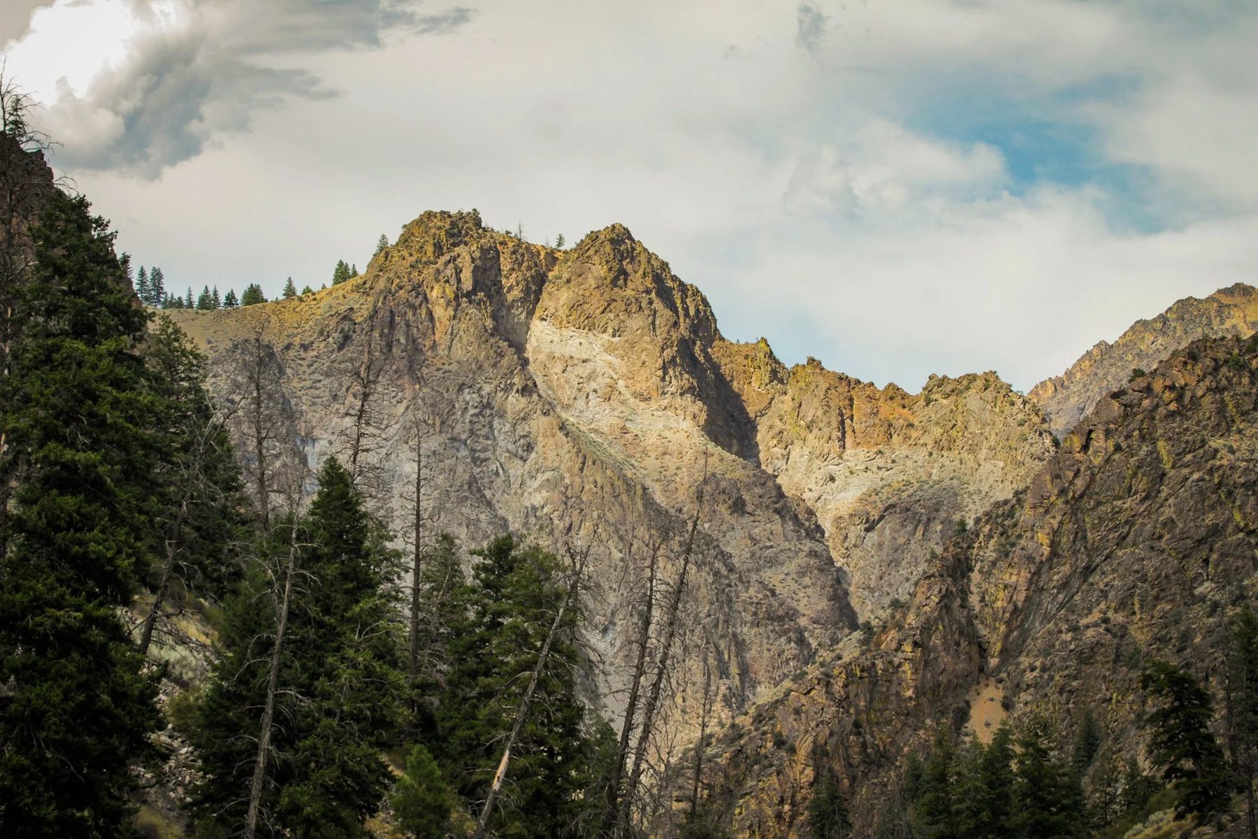 Jagged peaks above forest along the river corridor.